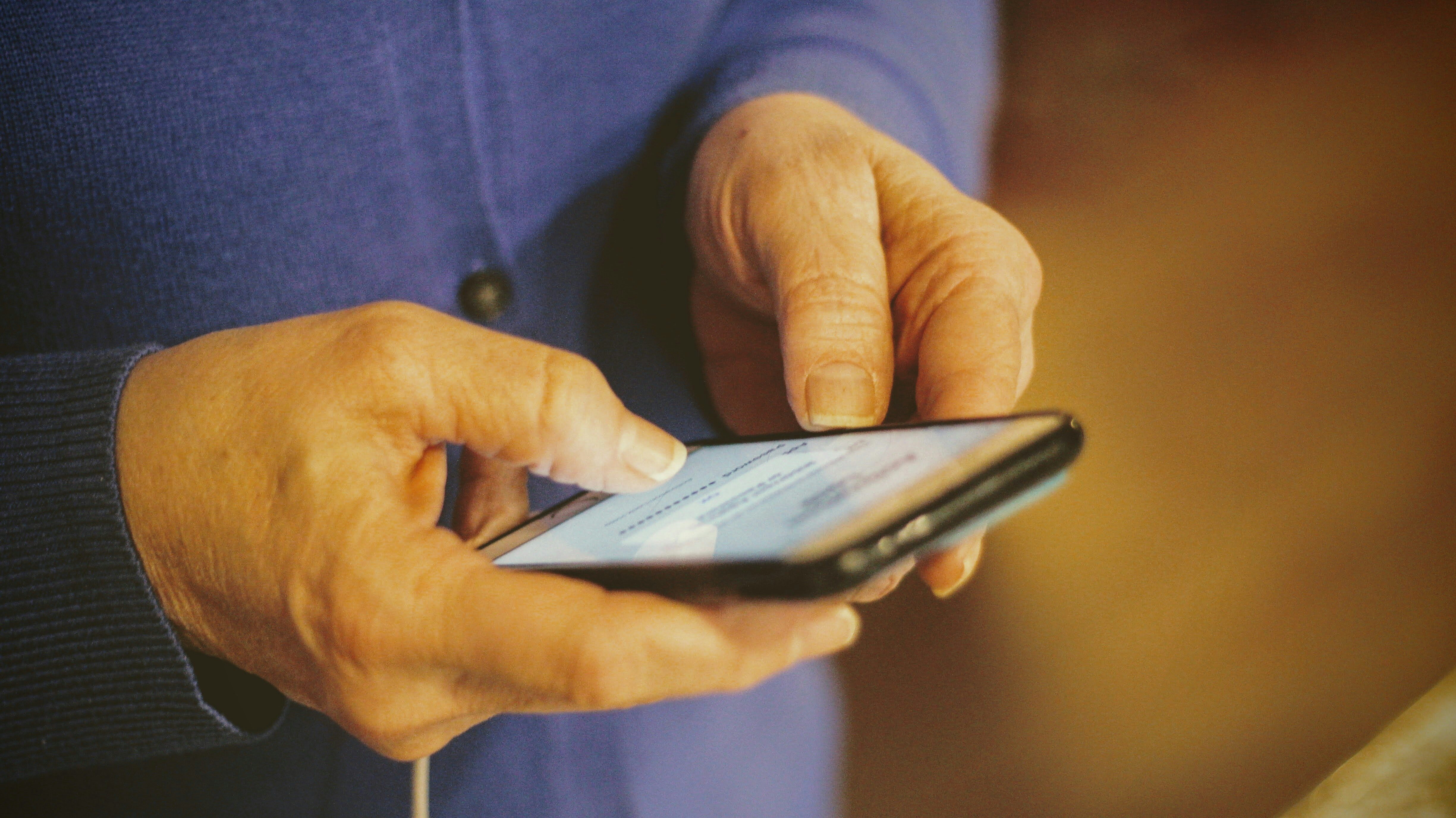 Mans hands handing phone