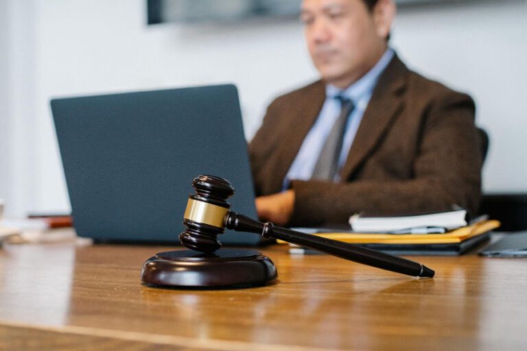 Man sitting behind a desk with a gavel on it.